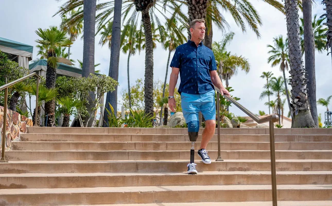 Mann mit Beinprothese geht eine Treppe hinunter
